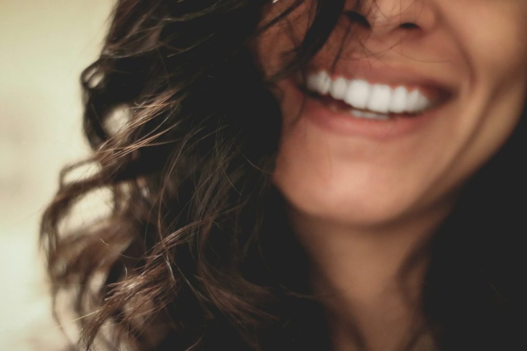 A woman smiling, showing an even set of front teeth