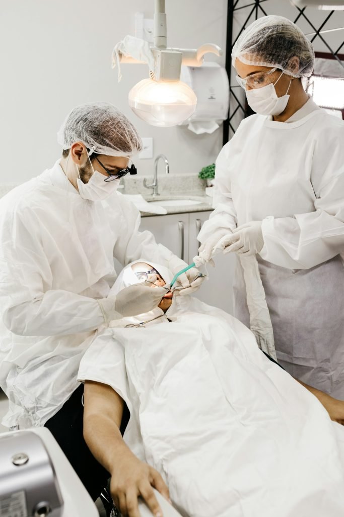 Two dentists in protective equipment carrying out a procedure