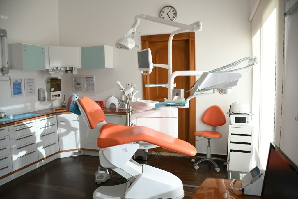 A clinical treatment room with dental chair and equipment